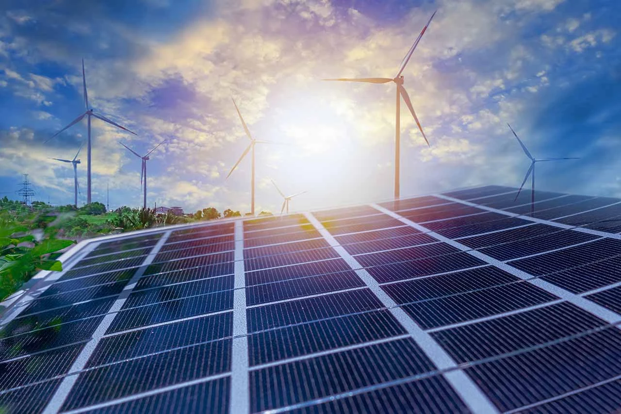 Solar panels and wind turbines representing the energy sector